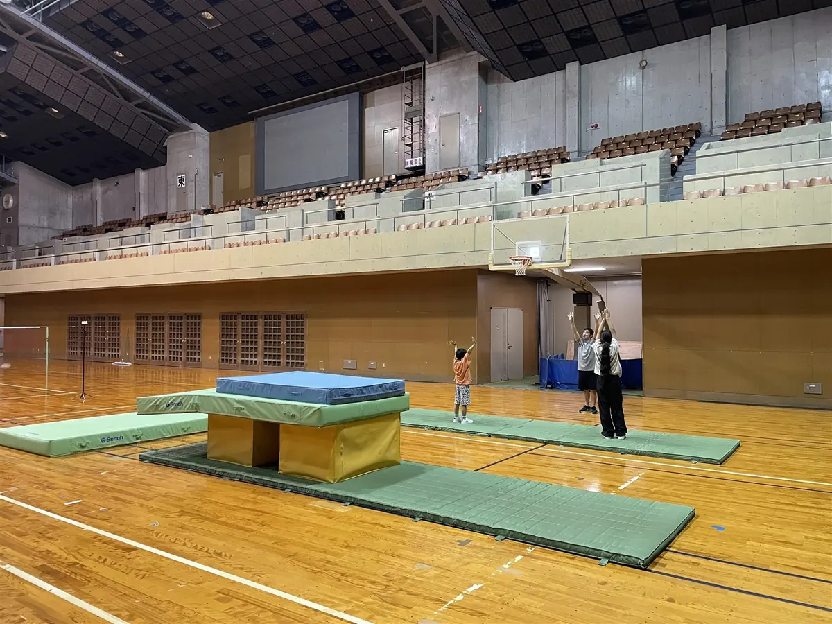 子どもが講師と体育館でレッスンに取り組む様子